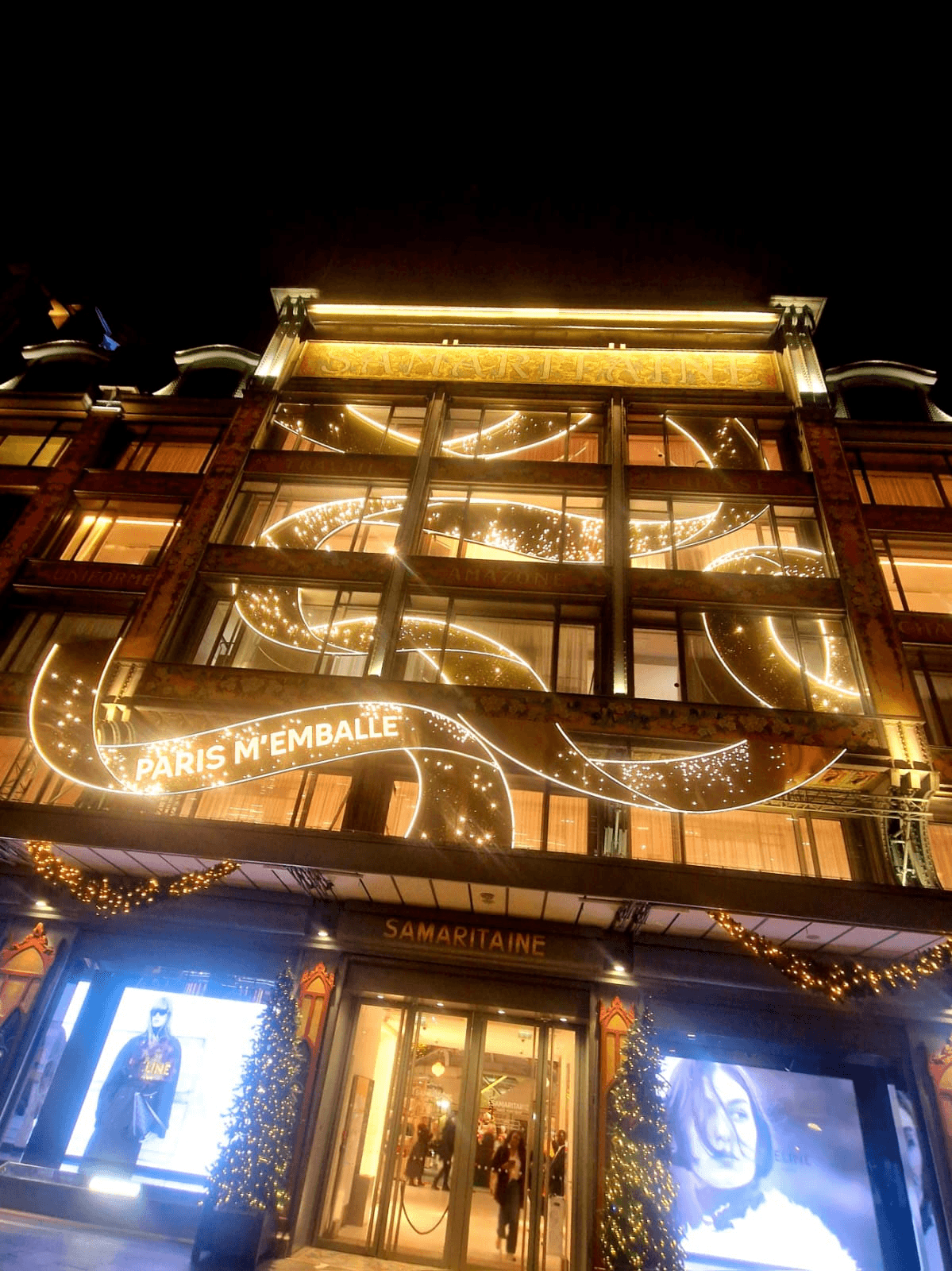 Façade Art Nouveau de La Samaritaine rue de la Monnaie illuminée pour les fêtes, avec l'inscription Paris m'emballe.